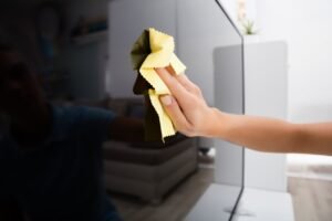 Microfiber cloth being used to clean a television screen safely