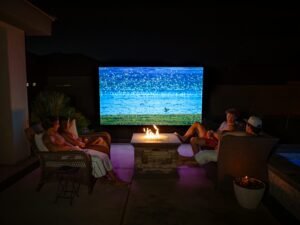 Living room prepared for a classic movie night with screen, sofa, blankets, and vintage film poster
