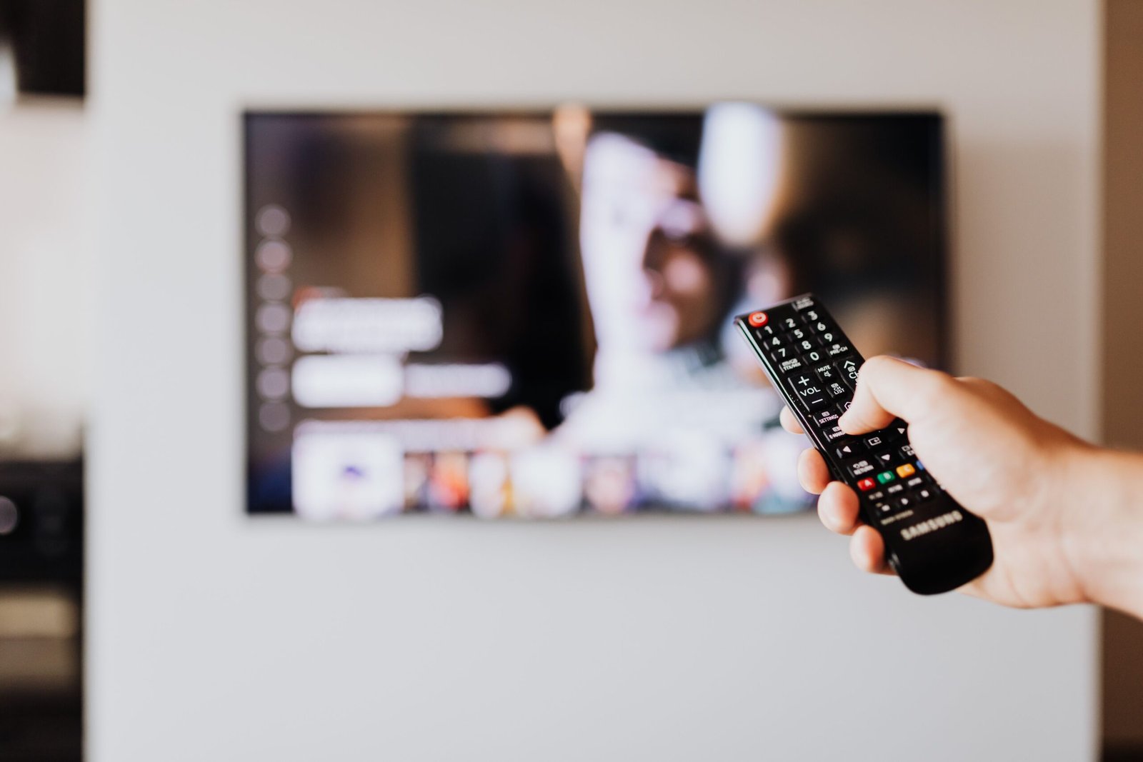 Over-the-shoulder view of a weekend watchlist and TV menu with a notebook showing a planned TV schedule