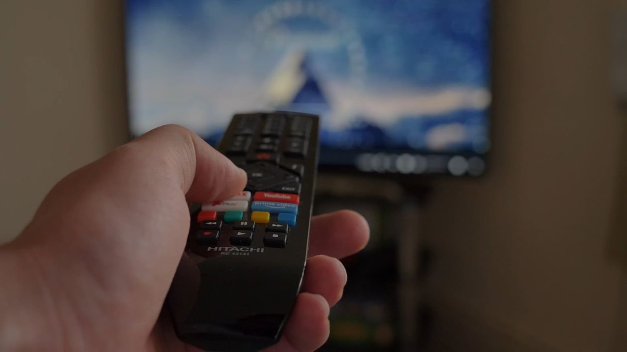 Person watching live sports on TV while checking mobile data usage on their phone