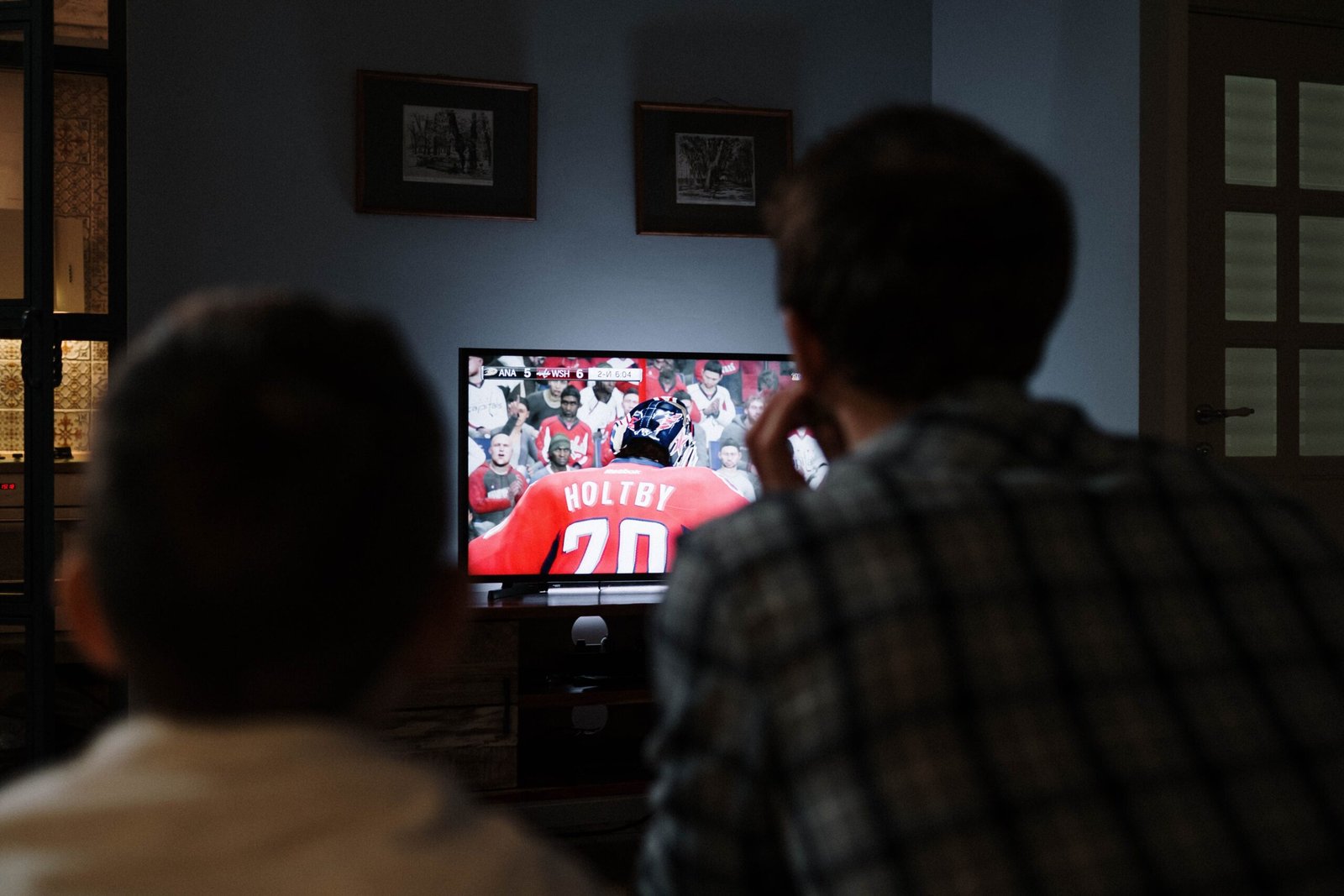 Living room with TV paused on a sports broadcast, remote and tablet ready for replay controls.