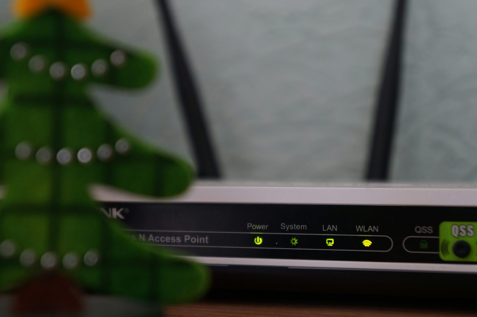 Smartphone displaying a one-time authentication code with a blurred TV in the background, representing streaming account two-factor authentication.